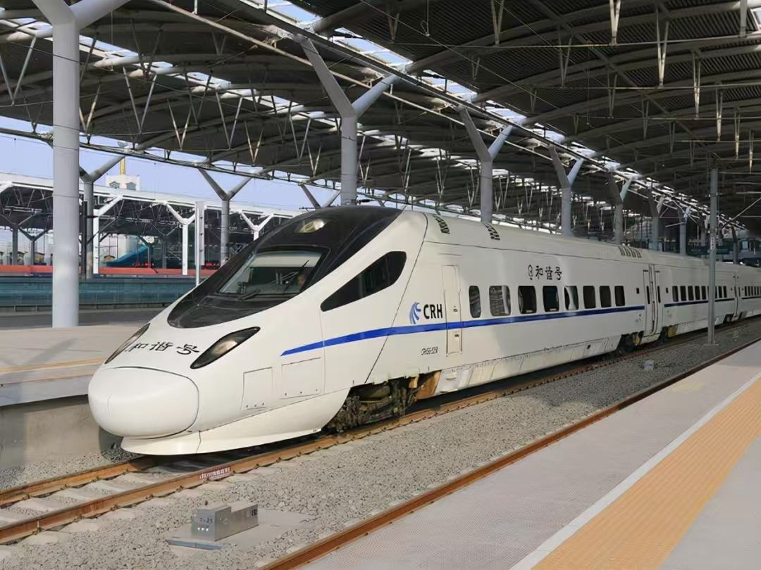 Older CRH Hexie electric multiple-unit train at a platform, white body with a blue stripe