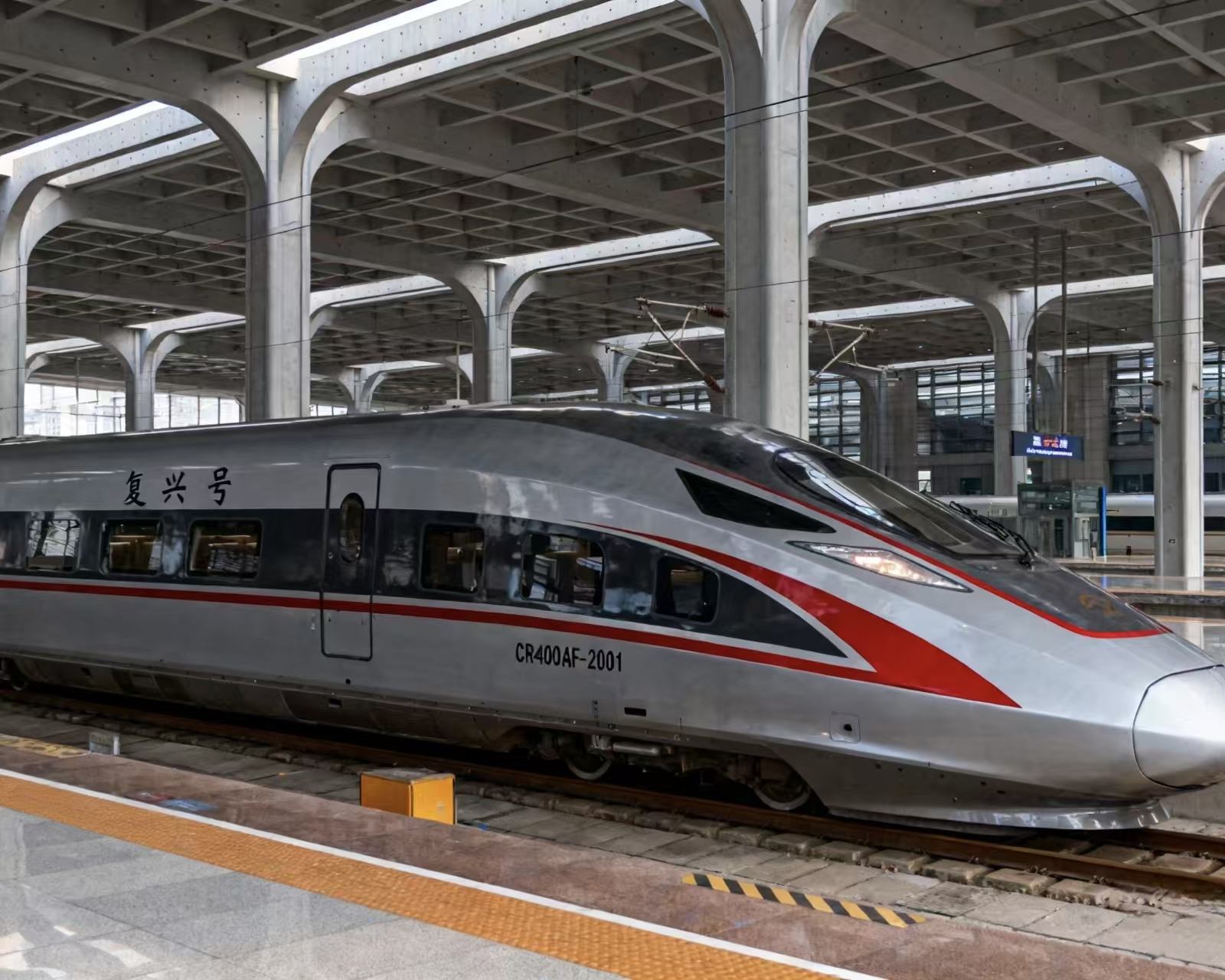 Fuxing CR400AF high-speed train at a station platform, silver body with a red accent stripe
