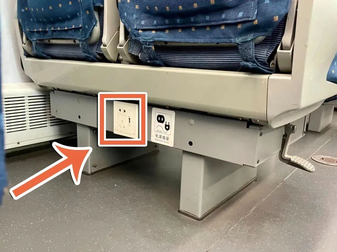 Standard Chinese three-pin power socket beside a seat in a China high-speed train carriage