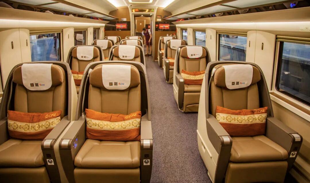 Business-class cabin of a China high-speed train with 2 plus 1 tan leather flat-recline seats