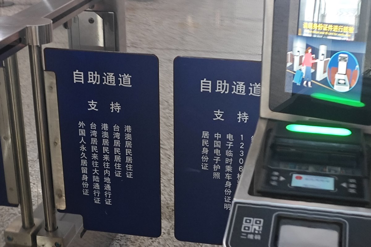 Sign above a Chinese railway station self-service entry channel listing the identity documents it accepts.