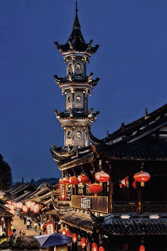 The Jinli-area pagoda tower lit at blue hour above the lantern-strung rooftops of the ancient street in Chengdu.