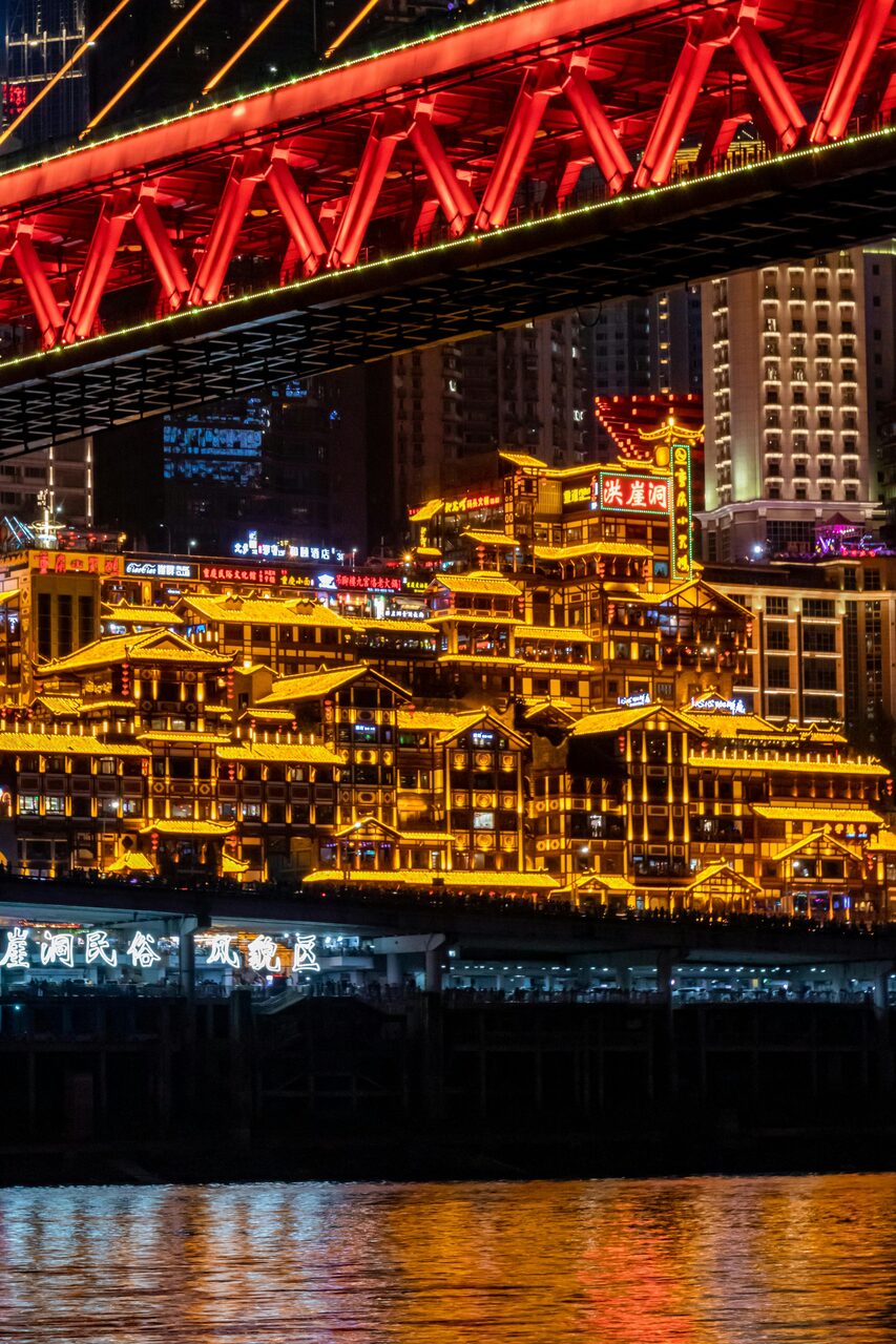 Hongyadong cliff-side stilt houses and neon lights reflected in the Jialing River at night, Chongqing.