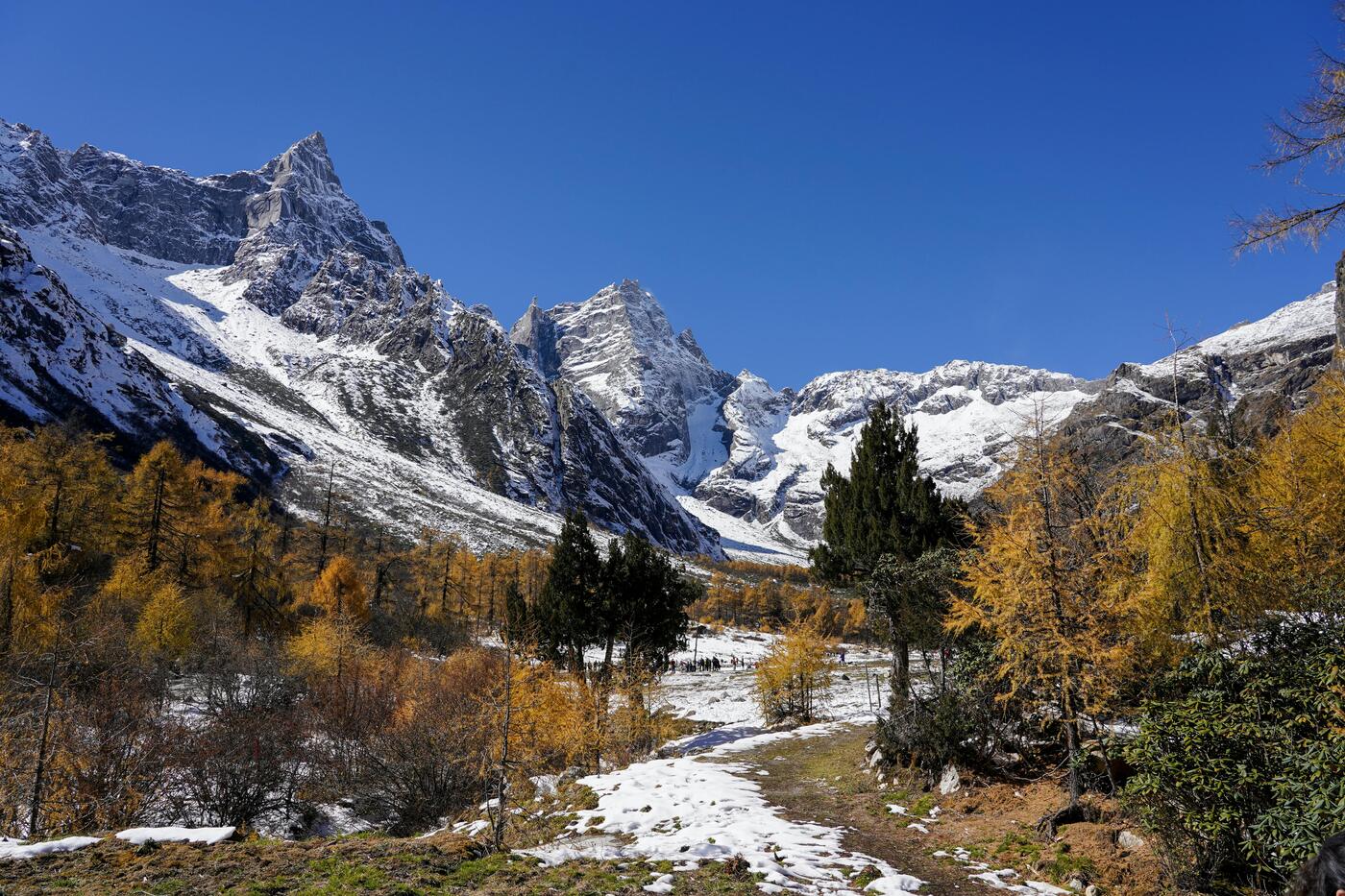 Jade Dragon Snow Mountain rising above Lijiang in Yunnan, snow-capped against a blue sky.