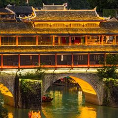 Hongqiao Bridge of Fenghuang Ancient Town — the two-storey covered bridge over the Tuojiang River, stilt houses along both banks.