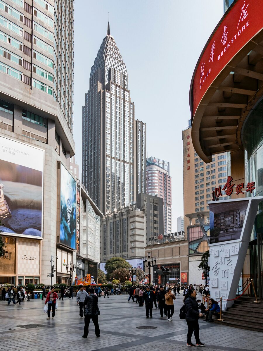 Chongqing Jiefangbei pedestrian street with crowds and illuminated shopfronts at night.