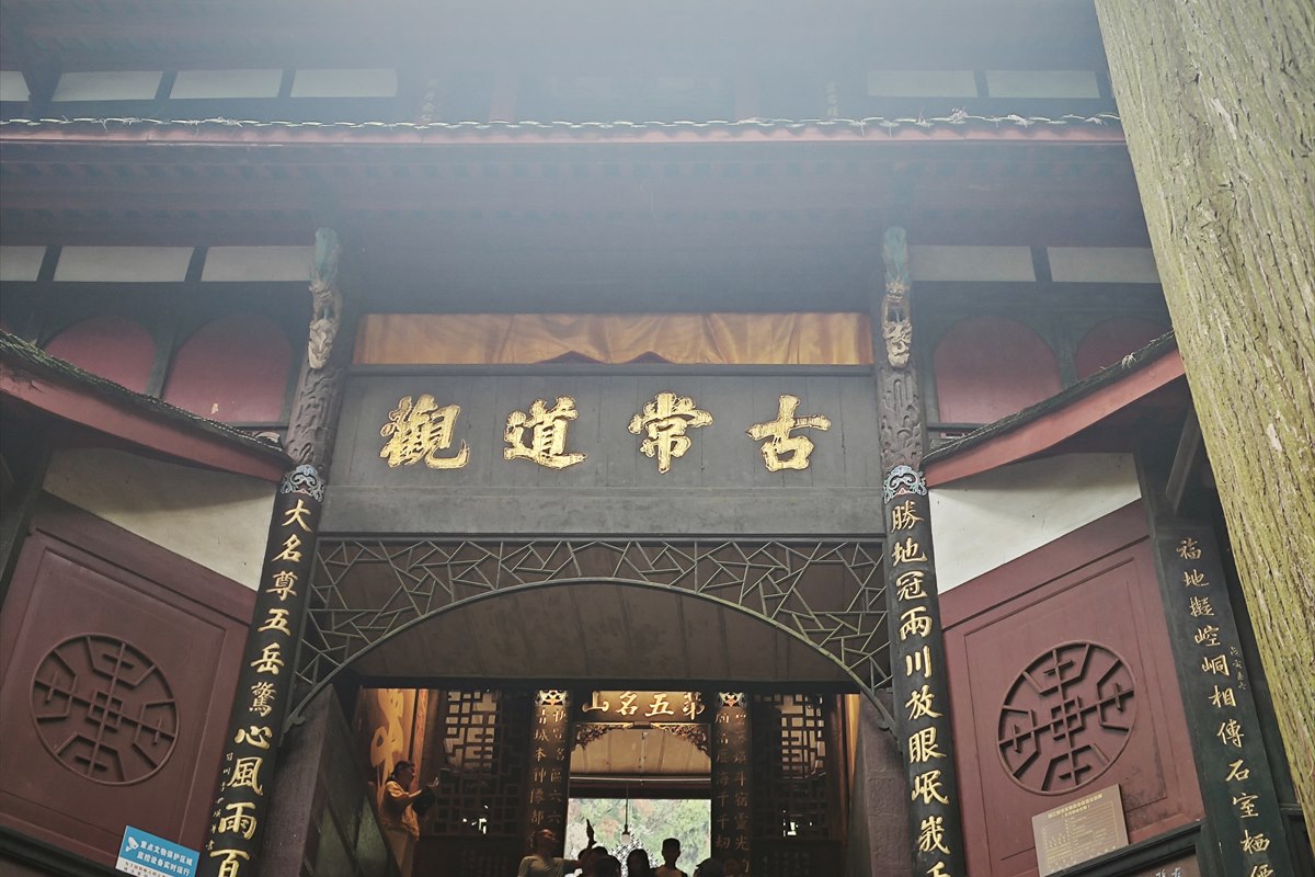 The timber gate of Gu Changdao Guan at Tianshi Cave, Mount Qingcheng, its gold plaque flanked by carved couplets.