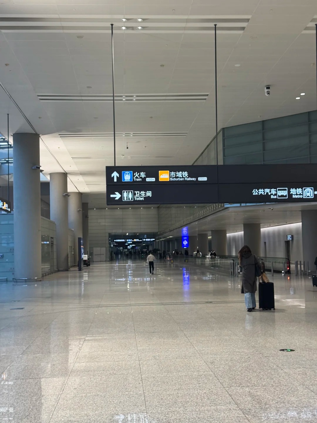 Hongqiao hub transfer corridor with overhead signs to the train station and suburban railway