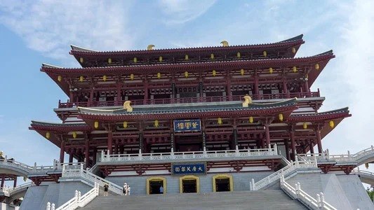 Ziyun Tower head-on in flat midday sun against a plain blue sky, its grand staircase empty apart from two distant figures.