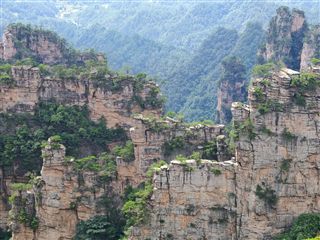 The Natural Great Wall of Yangjiajie — parallel blade-thin quartz-sandstone peak walls stacked behind each other, Zhangjiajie