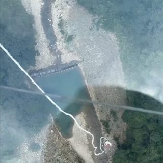 Looking straight down from the glass bridge along the bungee cord to the canyon river far below.